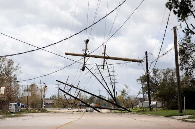 Toppled power poles and sagging wires on a residential street.