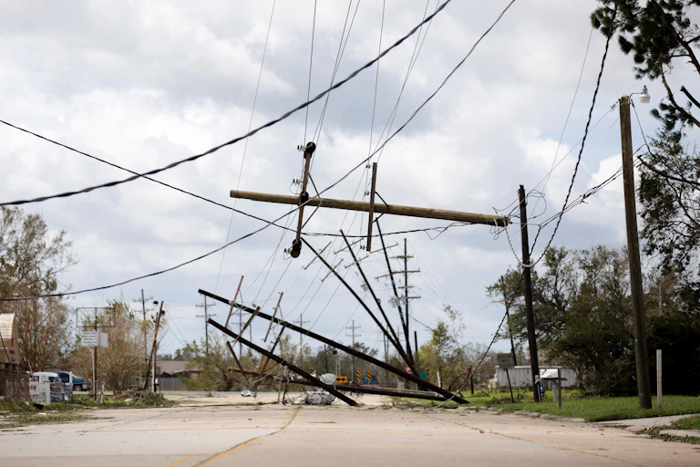 Toppled power poles and sagging wires on a residential street.