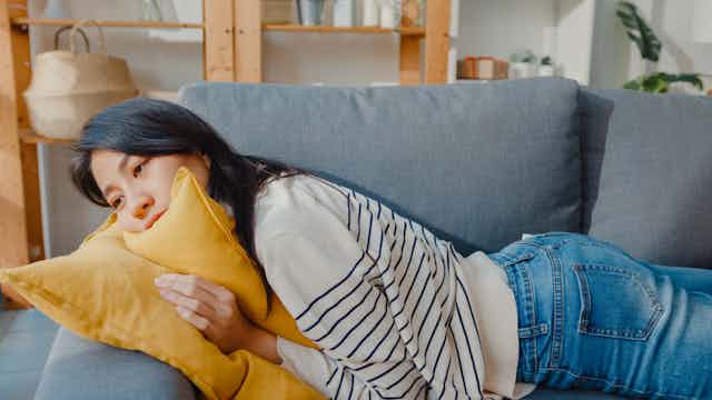 Young woman lying on sofa exhausted