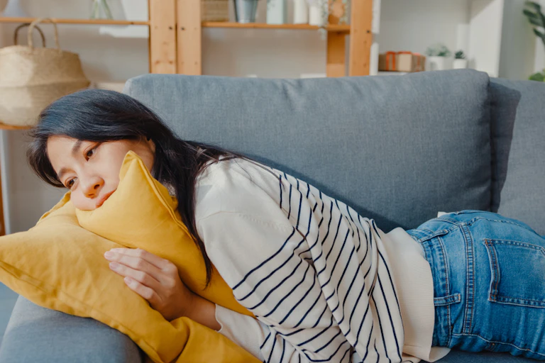 Young woman lying on sofa exhausted