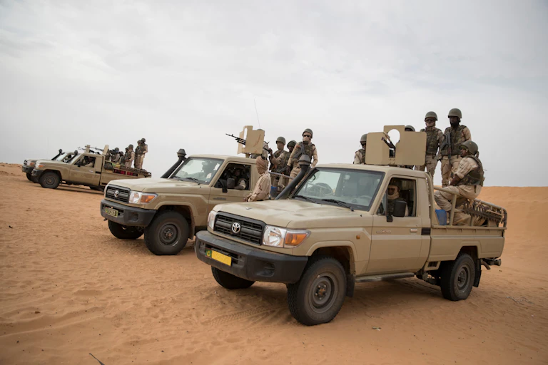 A group of soldiers mounted on the back of an attack vehicle