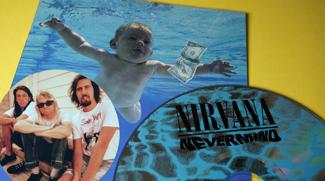 Nirvana Nevermind album cover, baby in swimming pool chasing a dollar