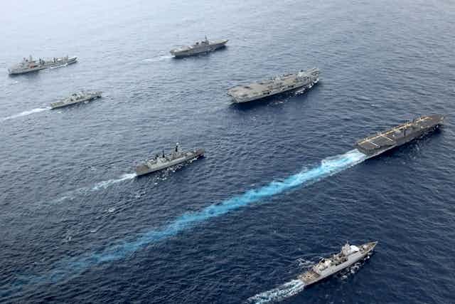 Aircraft carrier and war ships sailing in formation
