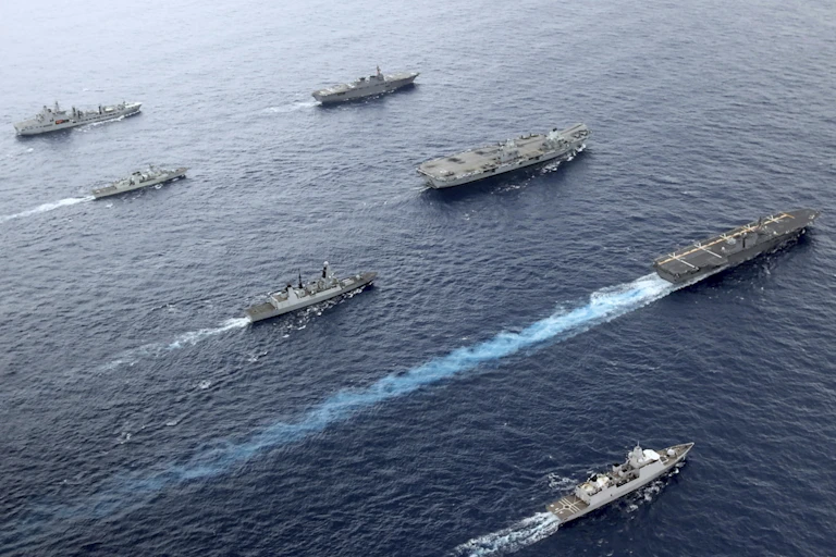 Aircraft carrier and war ships sailing in formation