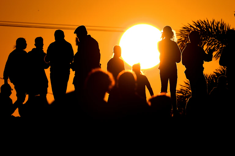 Silhouettes of people against sunset