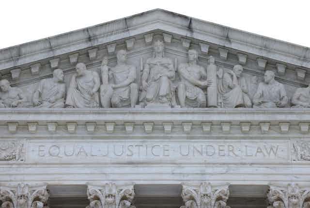 A relief sculpture of nine allegorical figures above the entrance to the Supreme Court Building, with Justice in the middle. Underneath, "Equal Justice Under Law" is inscribed.
