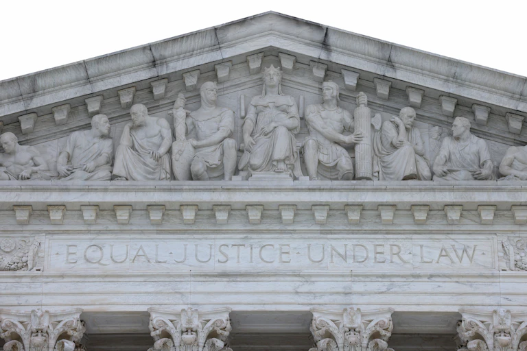 A relief sculpture of nine allegorical figures above the entrance to the Supreme Court Building, with Justice in the middle. Underneath, "Equal Justice Under Law" is inscribed.