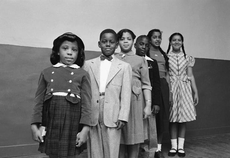 Six Black schoolchildren involved in the Brown v. Board of Education case, dressed up and standing in a line.