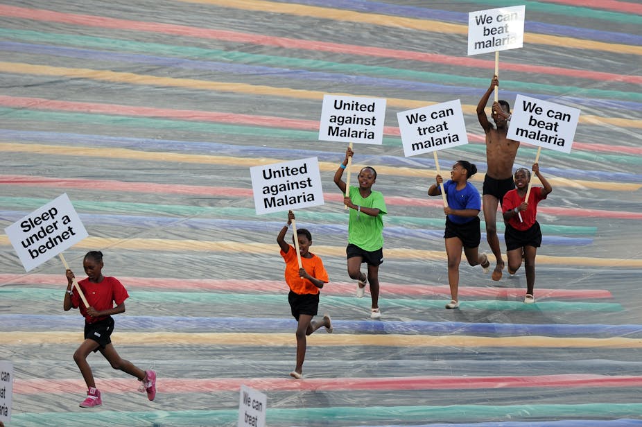 Children run with advertising banners for the fight against malaria during a ceremony held ahead of the 2013 African Cup of Nations final football match Nigeria vs Burkina Faso, on February 10, 2013 in Johannesburg. 