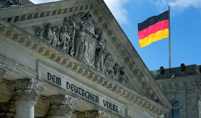 The German Reichstag with a German flag flying.