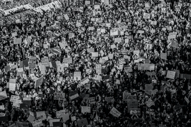 A black and white aerial image of a large protest.Some signs say: 'I can't breath,' others say, "Black Lives Matter," others: "No Justice no peace."