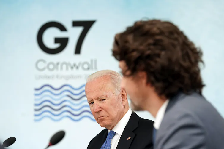 Biden looks down as Justin Trudeau speaks.