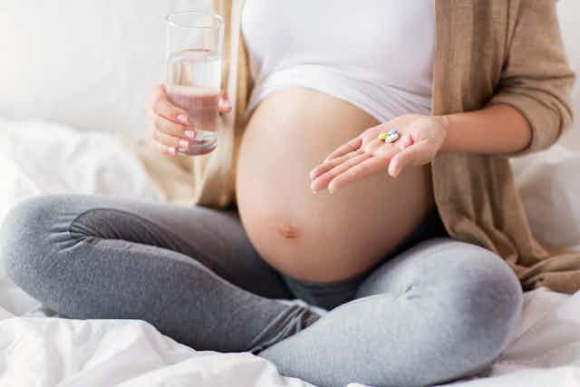pregnant person with pills