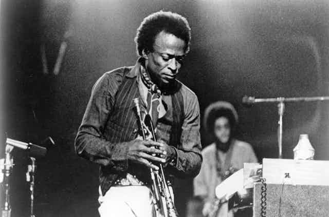 Miles Davis on stage with his trumpet.