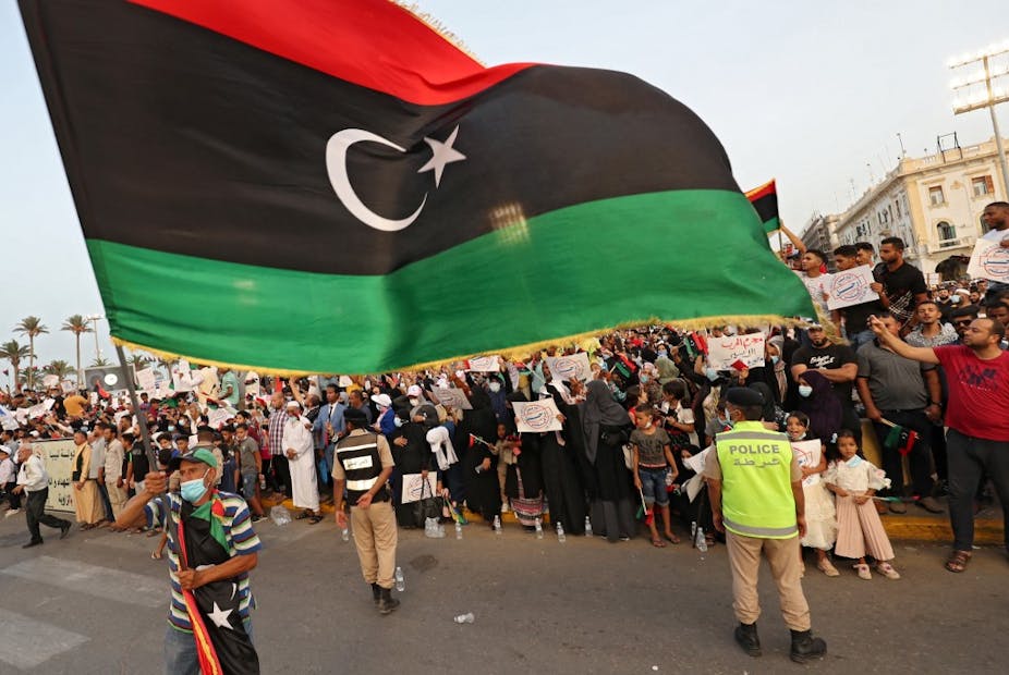 Personnes brandissant le drapeau libyen sur une place