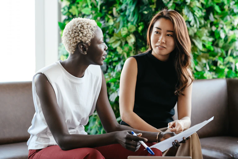 Two women talk in an office setting.