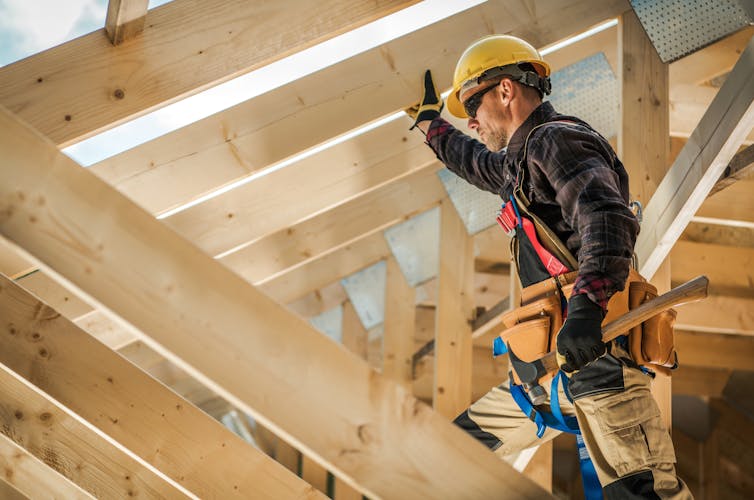 A builder works on a roof.