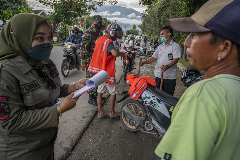 Petugas bermasker berbicara dengan warga tidak bermasker.