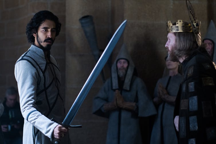 Dev Patel holds a sword.