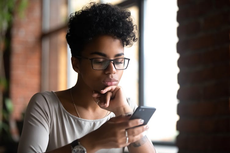 A woman looks at her phone.