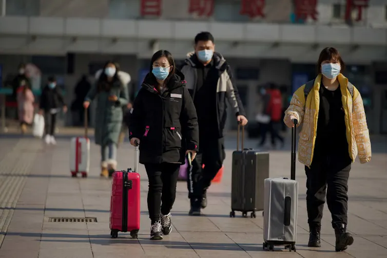 People arrive at Beijing railway station on February 8, 2021, ahead of the biggest holiday of the year, the Lunar New Year, which ushers in the Year of the Ox on February 12