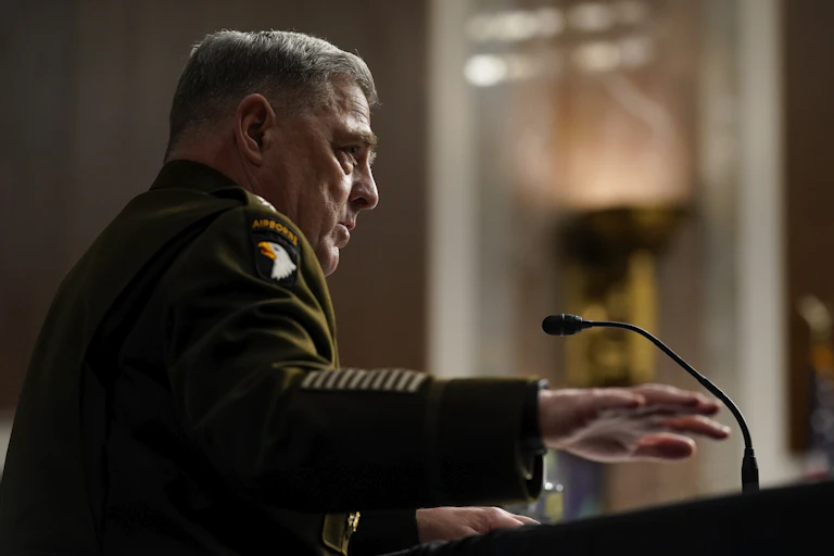 A man in military uniform speaks into a microphone.