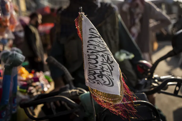 A Taliban flag on the front of a motorbike.