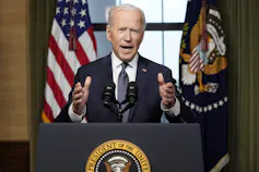Biden speaks from behind a podium.