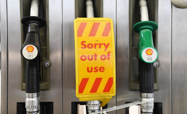 Petrol bowsers, with one displaying a 'Sorry out of use' sign.