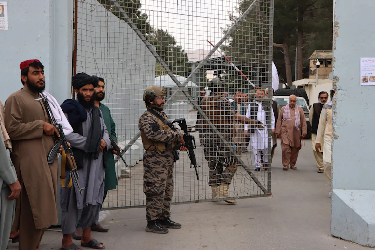 Taliban fighters in Afghan dress and military uniforms guard the gates at Kabul airport.