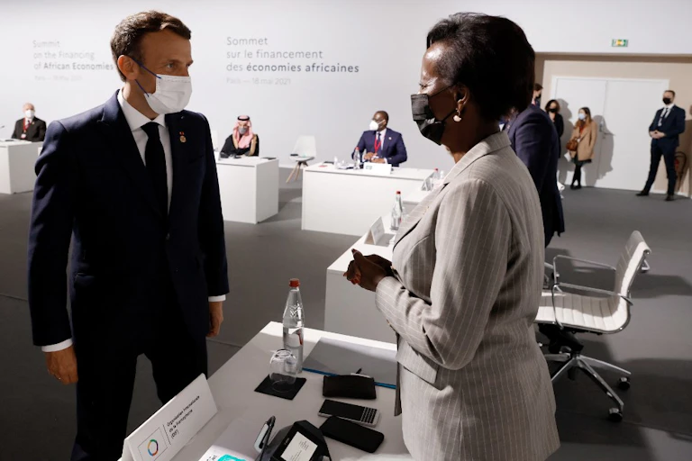 Emmanuel Macron fait face à Louise Mushikiwabo dans une salle de conférence.