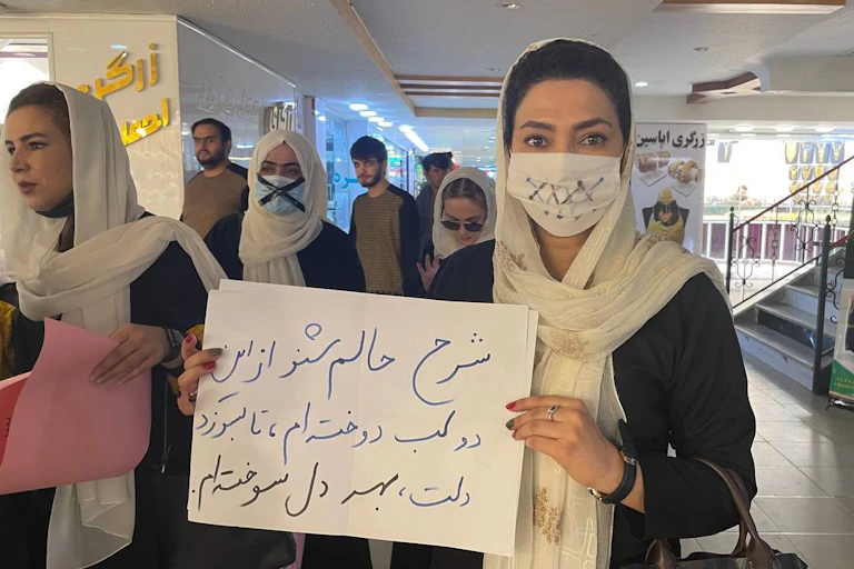 Afghan women hold banners and put a tape on their mouths during a "silent protest" for education rights in Kabul.