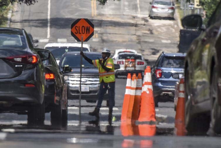 A worker in a reflective vest holds a
