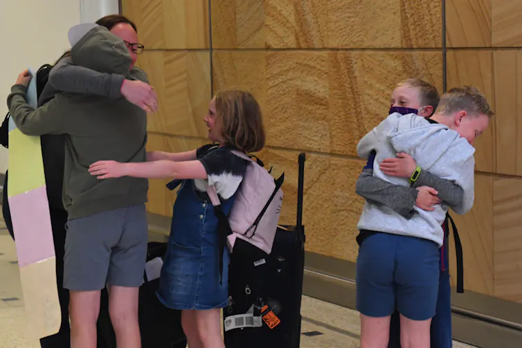 family hugs at airport