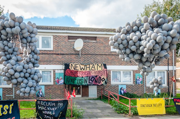 Balloons and hand-drawn posters outside a low-rise council block in London