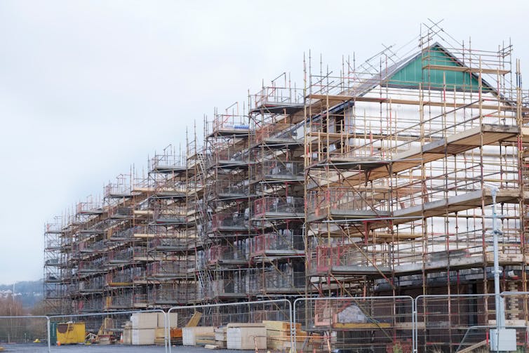 Large-scale construction project shroud in scaffolding against a pale sky
