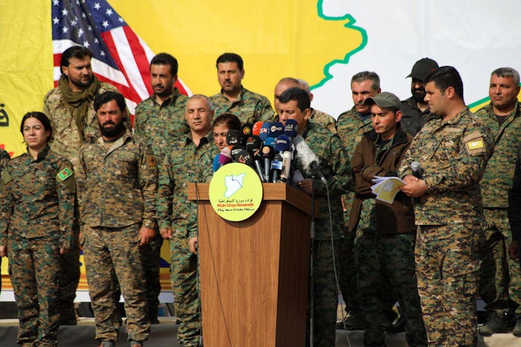 Syrian Democratic Forces commander Mazloum Abdi with other SDF officers celebrating military victory against ISIS in 2019.