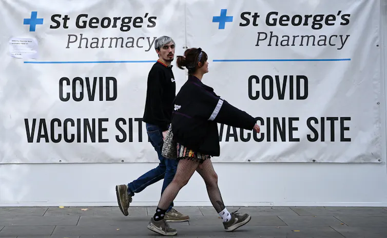 Two young people leaving a COVID-19 vaccine centre