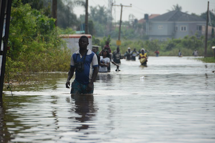 A man wades through a flooded street.