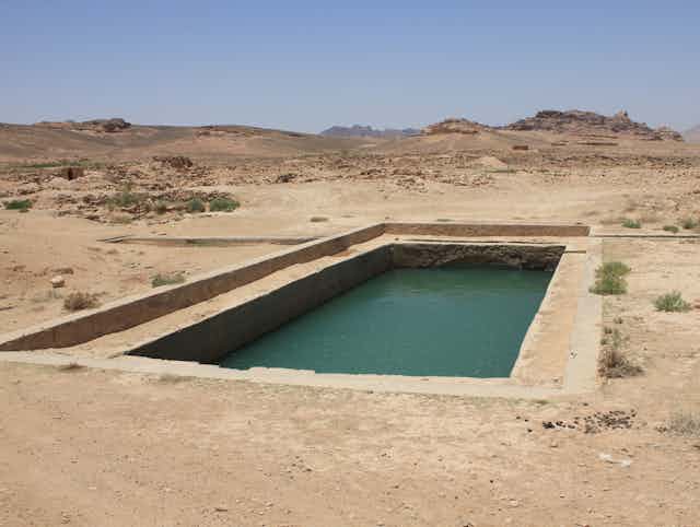 A rectangular pool carved into an arid landscape.