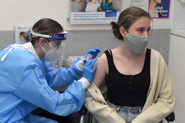 Person receiving COVID-19 vaccine from health-care worker
