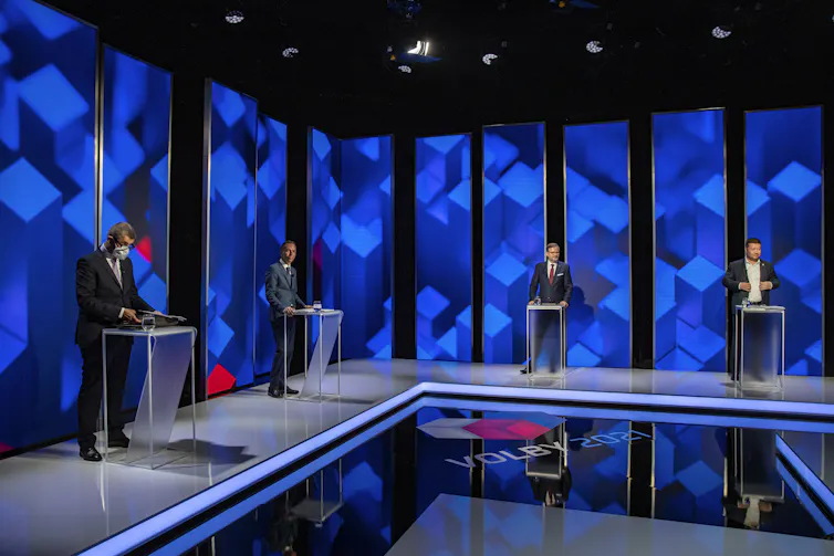 The four main candidates in the Czech election standing behind lecturns on a TV studio set.