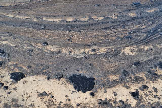 Sand with globs and streaks of crude oil.