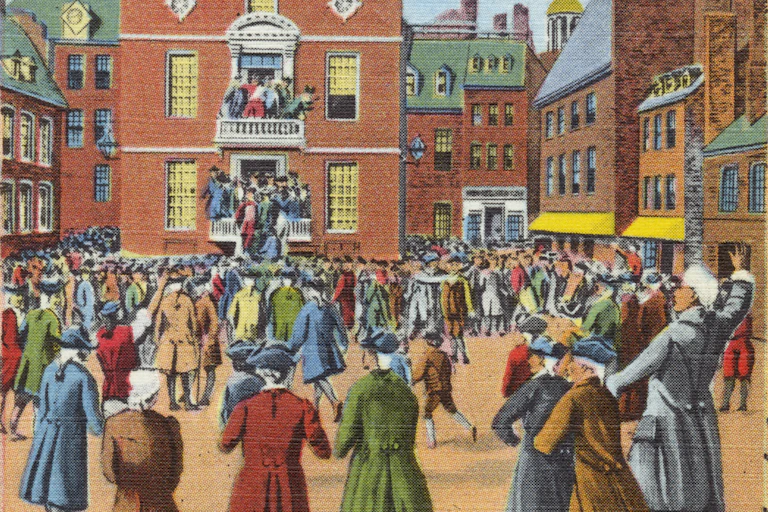 A crowd outside a brick building, with speakers on a balcony