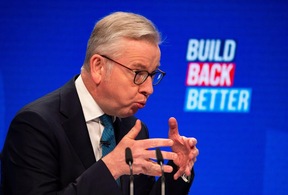 Michael Gove making a speech in front of a sign reading 'build back better'.