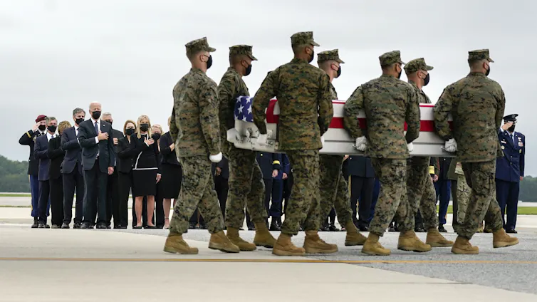 Marines carry a coffin draped in an American flag