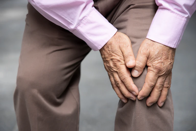 Una persona mayor se duele de la rodilla.