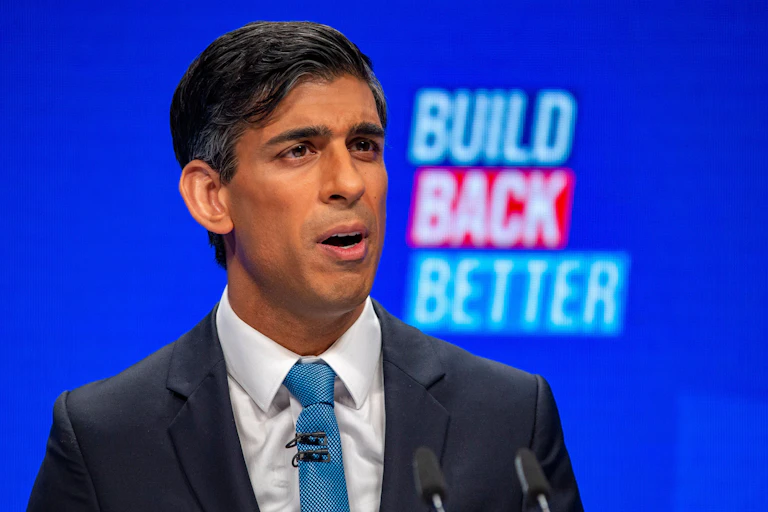 Chancellor of the exchequer, Rishi Sunak, speaks at the Conservative Party conference. A blue screen with the words 'Build Back Better' is behind him.