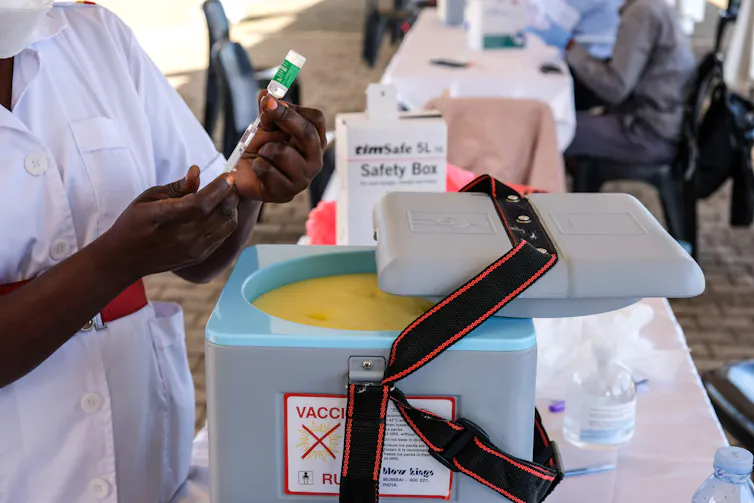 A health worker preparing a dose of COVID vaccine in Uganda