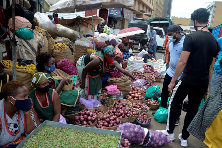 People wearing face masks visit a food market.